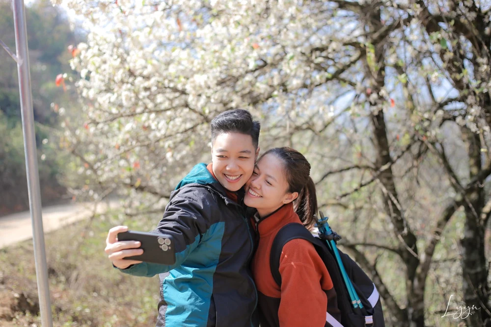 Du khách check-in bên hoa sơn tra. Ảnh: LẠC LẠC.