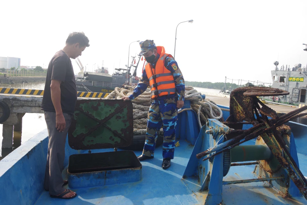 Cán bộ Hải đoàn 38 Bộ đội Biên phòng kiểm tra số dầu lậu mà tàu HP 3911 vận chuyển. Ảnh: VĂN MINH