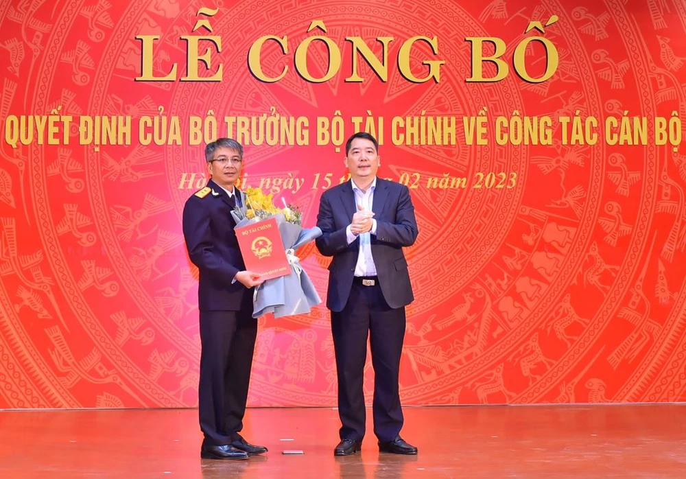 Thứ trưởng Cao Anh Tuấn trao quyết định và chúc mừng Quyền Tổng cục trưởng Tổng cục Thuế Mai Xuân Thành (bên trái). Ảnh: CHÂN LUẬN