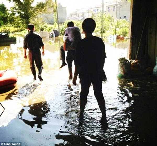 Sợ hỏng giày, quan chức ngồi trên lưng người dân thị sát bão lũ 1