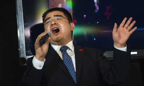 Ông Chen Guangbiao trình bày một ca khúc trong bữa trưa cho người vô gia cư. Ảnh:Reuters. tag-reuters-1-6364-1403757351.jpg