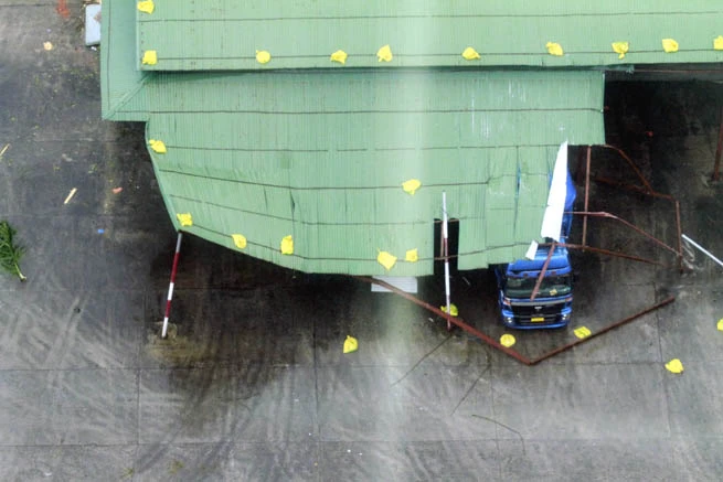 Bão làm sập mái tôn đè vào một xe tải.