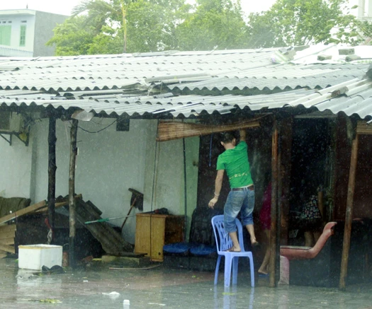 Người dân nghèo Móng Cái trở về gia cố ngôi nhà của mình.