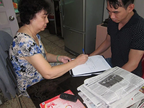 Một thừa phát lại (trái) đang lập vi bằng tại TP HCM Ảnh: PHẠM GIANG