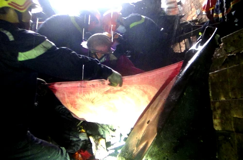 Lính cứu hộ dùng mền quấn nạn nhân để đưa ra ngoài. Ảnh: