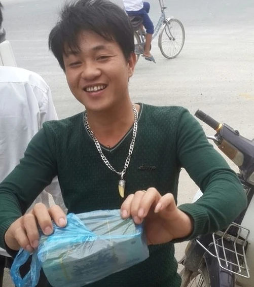 Anh Trần Duy Tư và số tiền nhặt được. Ảnh: Nguyễn Tình.