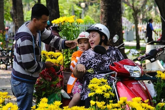 Giá hoa giảm sâu, nhiều khách đi bát phố cũng ghé vào hỏi mua. Một khách hàng tên Nga hào hứng chia sẻ, thấy giá rẻ, hoa lại đẹp nên đang đi trên đường chị tạt vào mua hoa cúc về chưng Tết.