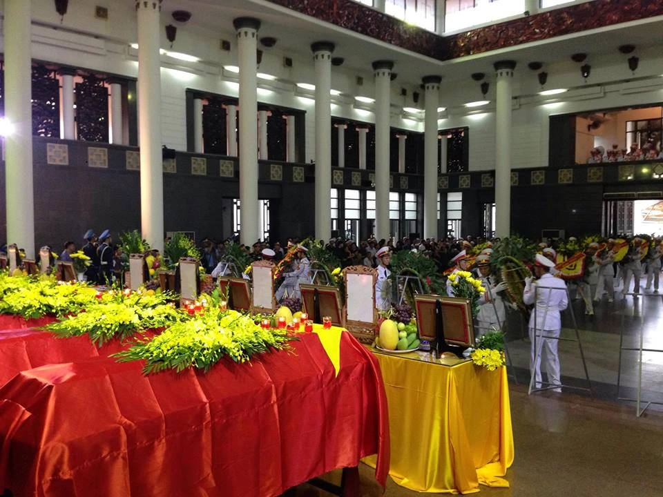 Di ảnh của 9 quân nhân được xếp thành hàng ngang trên hai chiếc bàn dài 