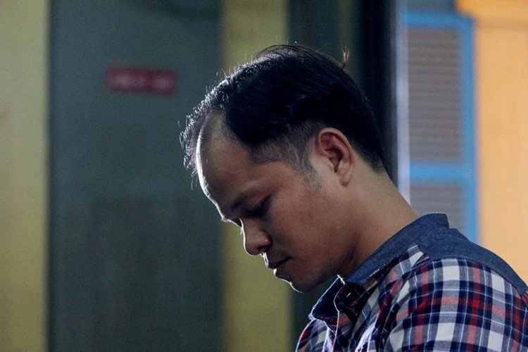 Bị cáo Minh cúi đầu chăm chú lắng nghe phần tranh luận của luật sư Hùng