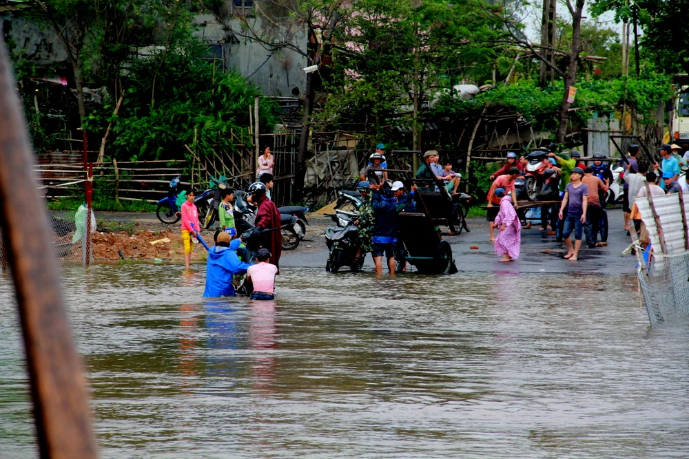 Một số người dân chuẩn bị xe bò chở phương tiện qua đoạn ngập nước