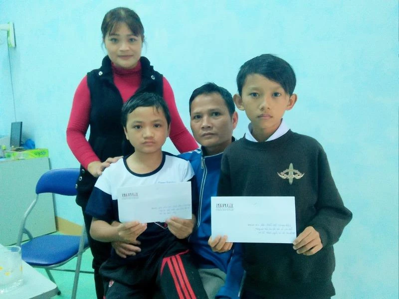 Hai em học sinh là Đinh Lâm Vũ (lớp 7C) và em Đào Quốc Việt (Quảng Ngãi) cùng nhận tiền hỗ trợ của báo. Ảnh Huy Trường