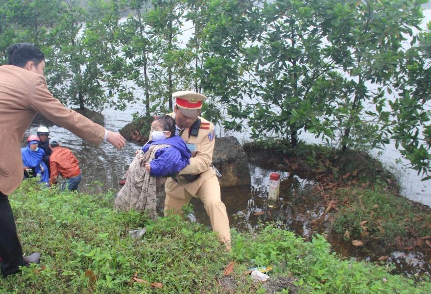 Cảnh sát giao thông và người dân giúp hai mẹ con bị tai nạn. ảnh: Anh Khoa.