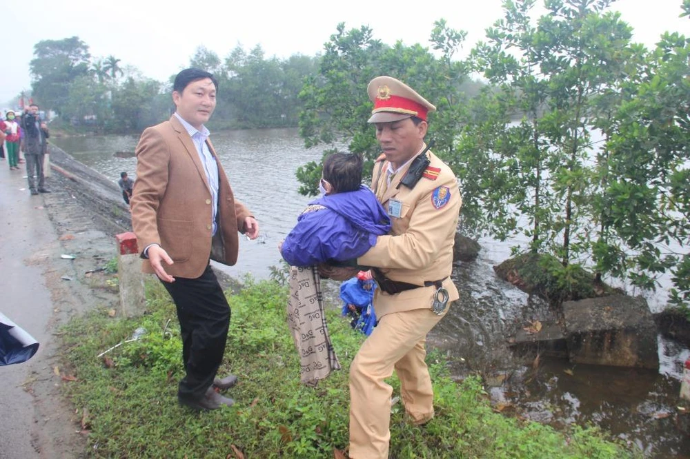 Cảnh sát giao thông và người dân giúp hai mẹ con bị tai nạn. ảnh: Anh Khoa.
