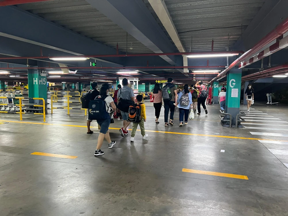 Hành khách kéo vali ra đầu đường Trường Sơn đón xe. Ảnh: ĐT.