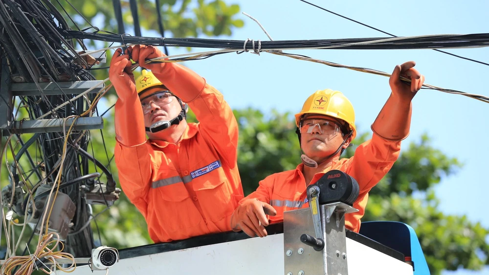 Công nhân EVNHCMC đang kiểm tra, bó gọn dây thông tin để đảm bảo an toàn điện.