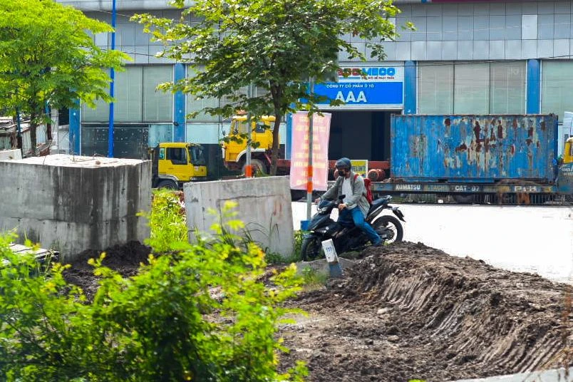 Xe máy cũng bất chấp leo lên vỉa hè - phần đang được thi công để đi xuống dạ cầu. Ảnh: HỮU HƯỚNG.