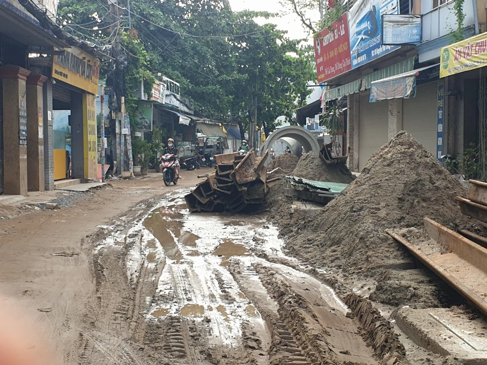 Đường lầy lội, vật liệu xây dựng chồng chất đầy đường.