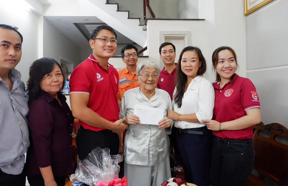 Phó Chủ tịch Công đoàn EVNHCMC Đặng Mỹ Ly (áo trắng) thăm hỏi Mẹ Việt Nam anh hùng Lê Thị Ánh (quận 6). VA.