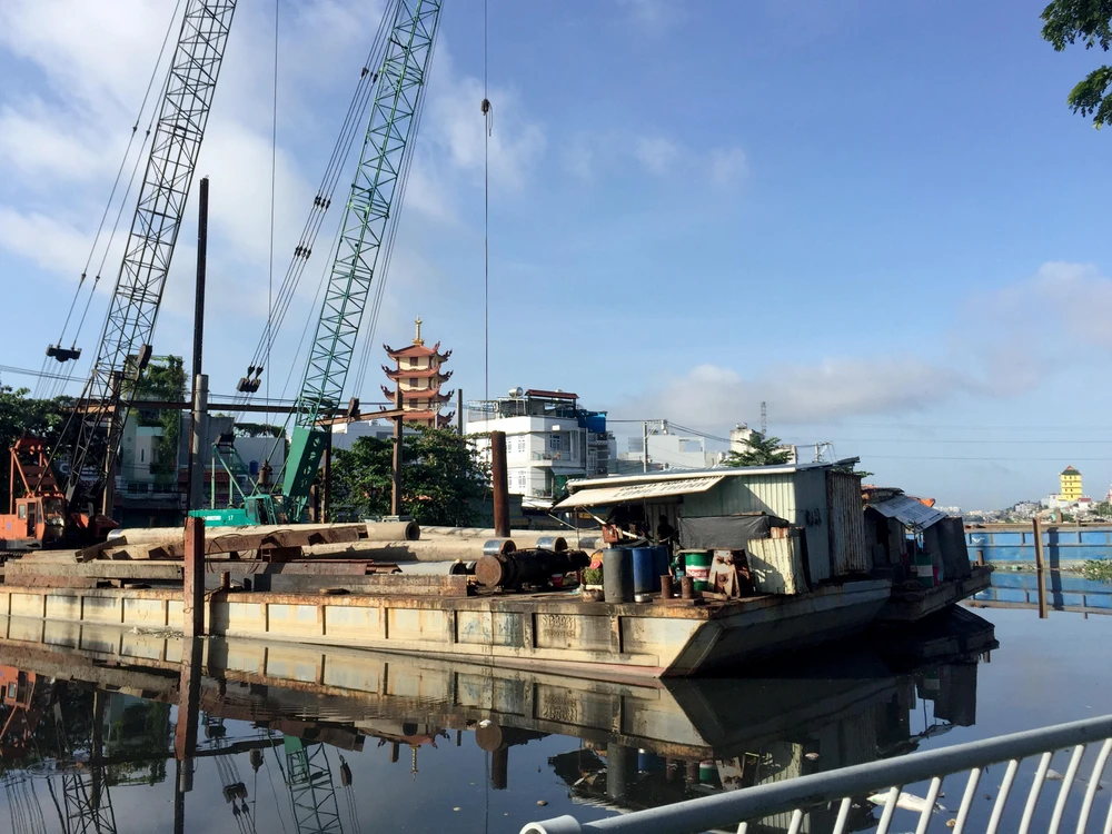 Dự án cải thiện môi trường nước TP.HCM khu vực bến Phú Định cũng hoang phế lâu ngày - sà lan không một bóng người đang đậu trên dòng kênh đen vì ô nhiễm.