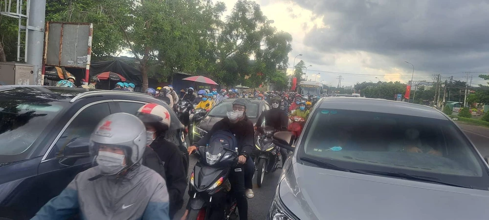 Dòng người xếp hàng trên Quốc lộ 1A. Ảnh: ANH SUNG.