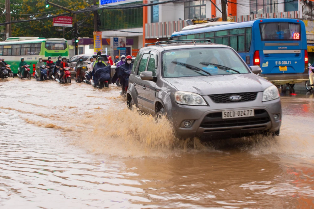 Người dân khó di chuyển vì ngập. Ảnh: HỮU HƯỚNG.