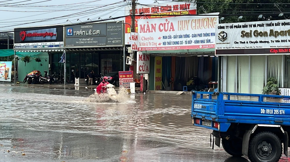 Người dân chật vật di chuyển qua điểm ngập.