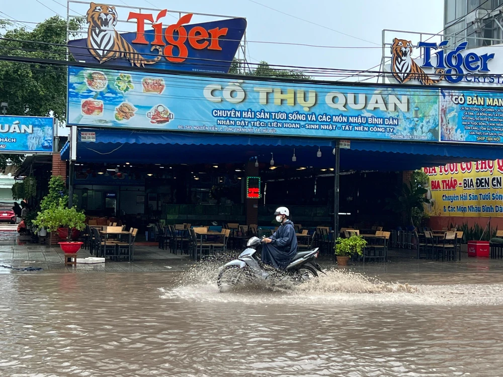 Người dân phải co chân lại để né ướt.