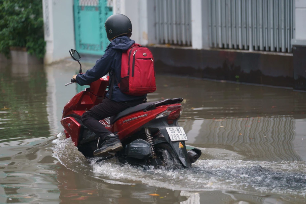 Người dân đi lại khó khăn khi triều cường dâng cao. Ảnh: NH.