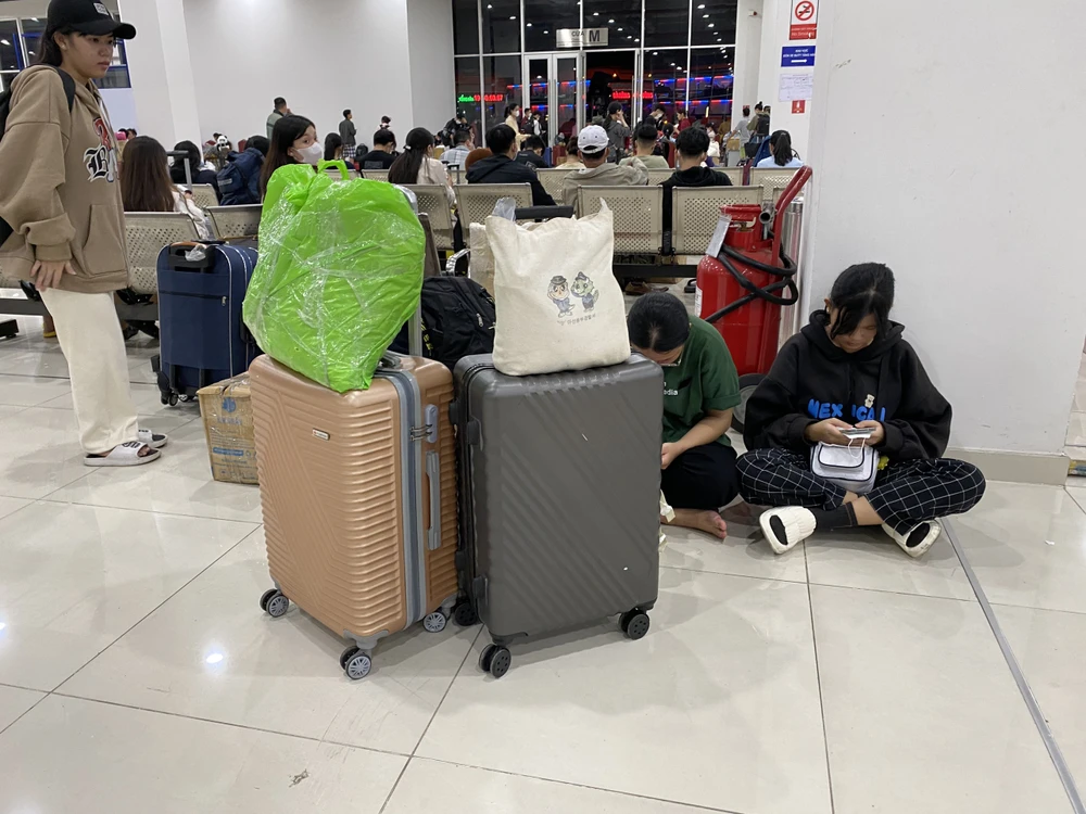 Với lượng hành khách đông đúc, thiếu ghế ngồi, nhiều hành khách đã phải ngồi xuống sàn nhà trong thời gian chờ chuyến đi.