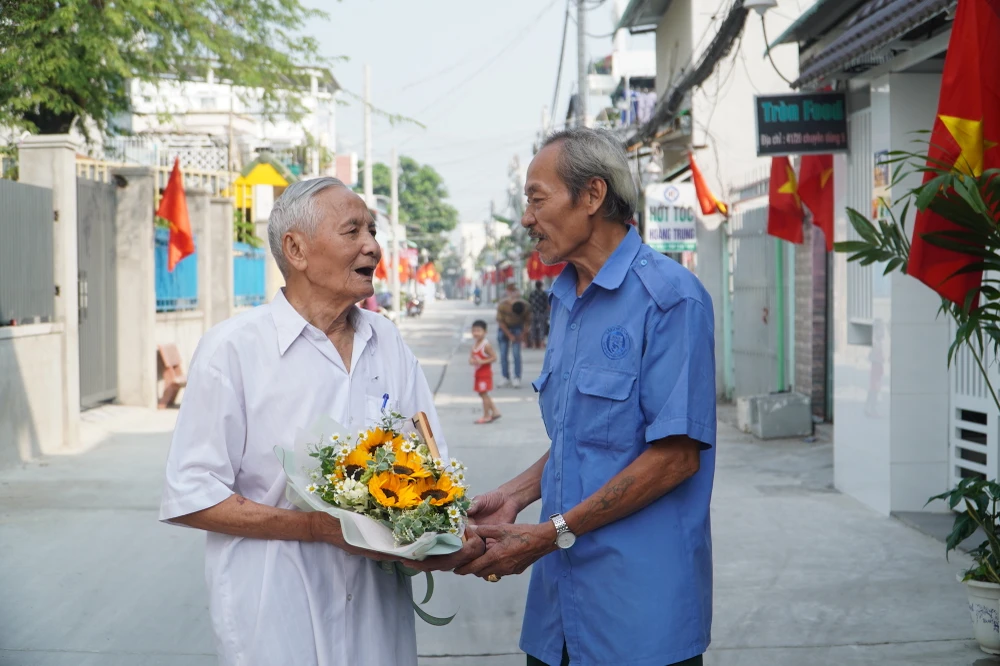Người dân vui mừng trong buổi lễ mừng công dự án Nâng cấp, mở rộng Hẻm 41 đường Chuyên Dùng 9, phường Phú Mỹ. Ảnh: BẢO PHƯƠNG.