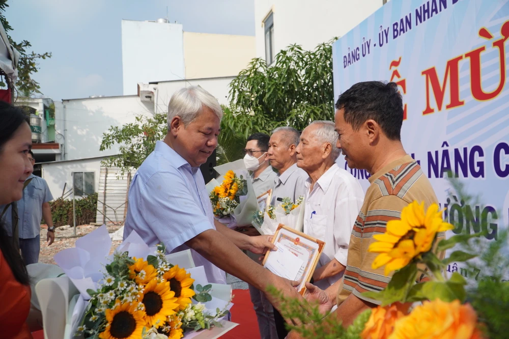 Lãnh đạo quận 7 trao bằng khen các hộ dân, tổ chức có nhiều đóng góp cho quận 7. Ảnh: BẢO PHƯƠNG.