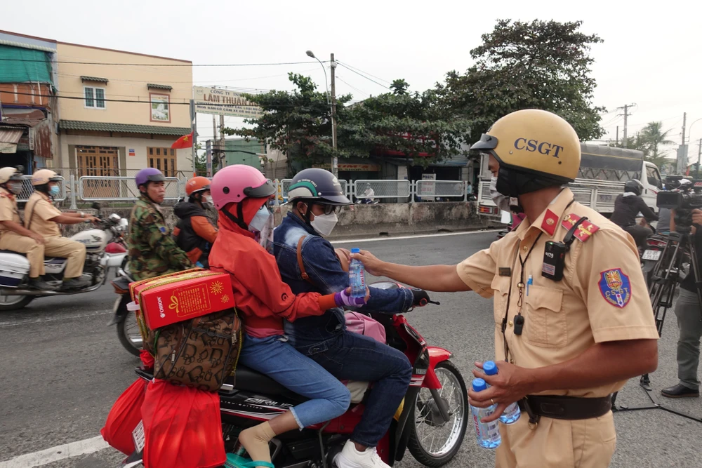 CSGT trao nước suối cho bà con về quê ăn tết.