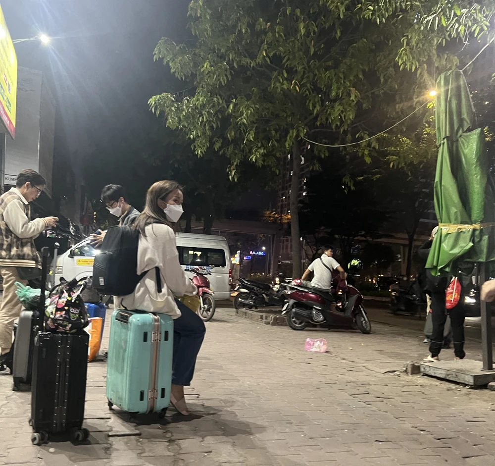 Hành khách chờ đón xe trên đường Điện Biên Phủ. Ảnh: ĐÀO TRANG.