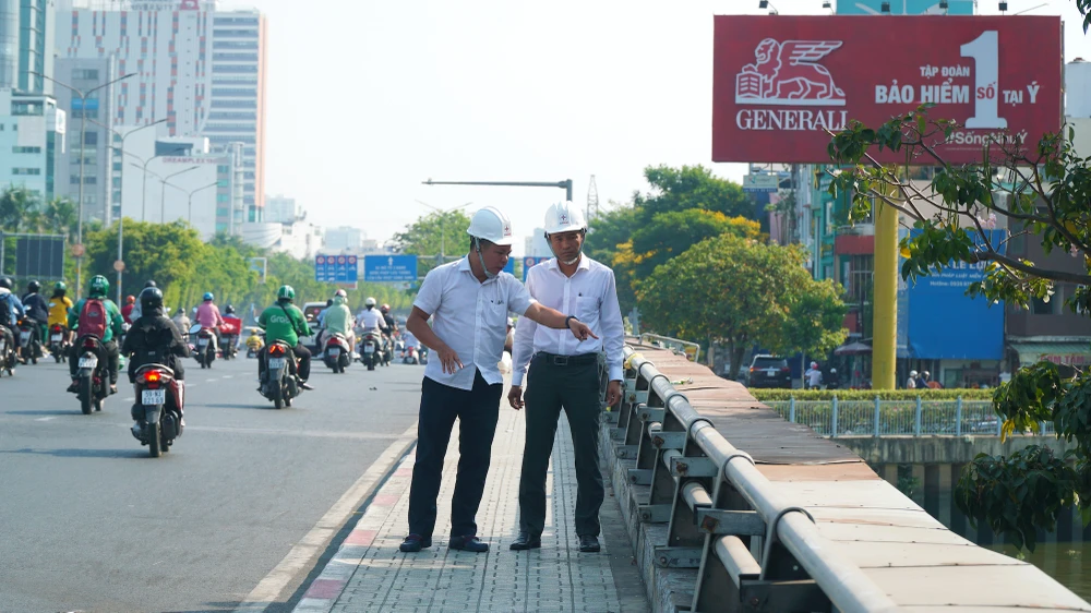 Lãnh đạo Công ty Điện lực Sài Gòn đang thị sát ở cầu Điện Biên Phủ, quận 1. Ảnh: Nguyễn Tiến.