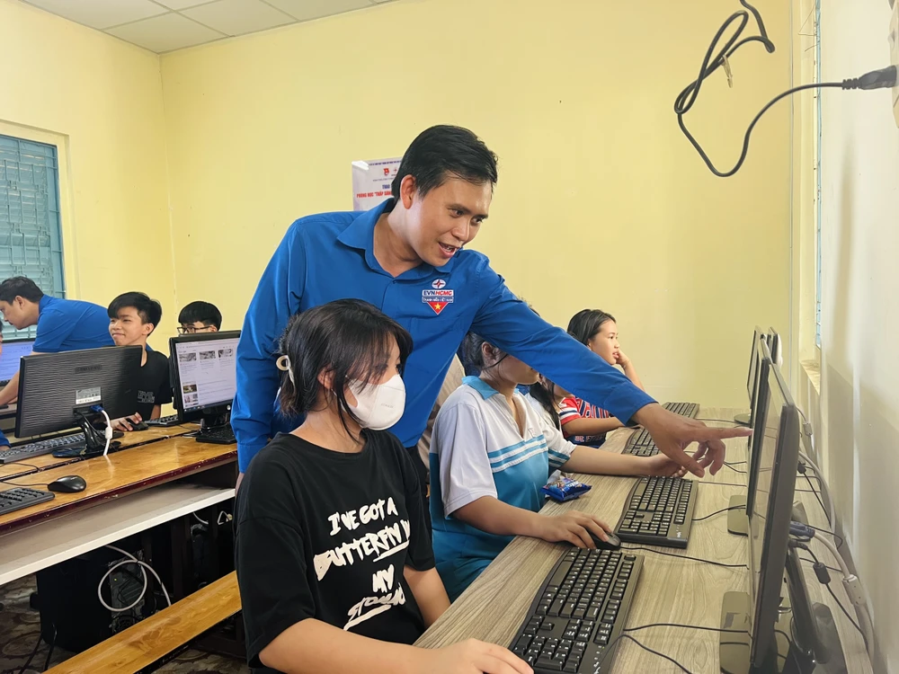 Anh Huỳnh Tấn Khương, Bí thư Đoàn thanh niên EVNHCMC, hỗ trợ các em cách truy cập, học tập trên máy tính. Ảnh: ĐT.