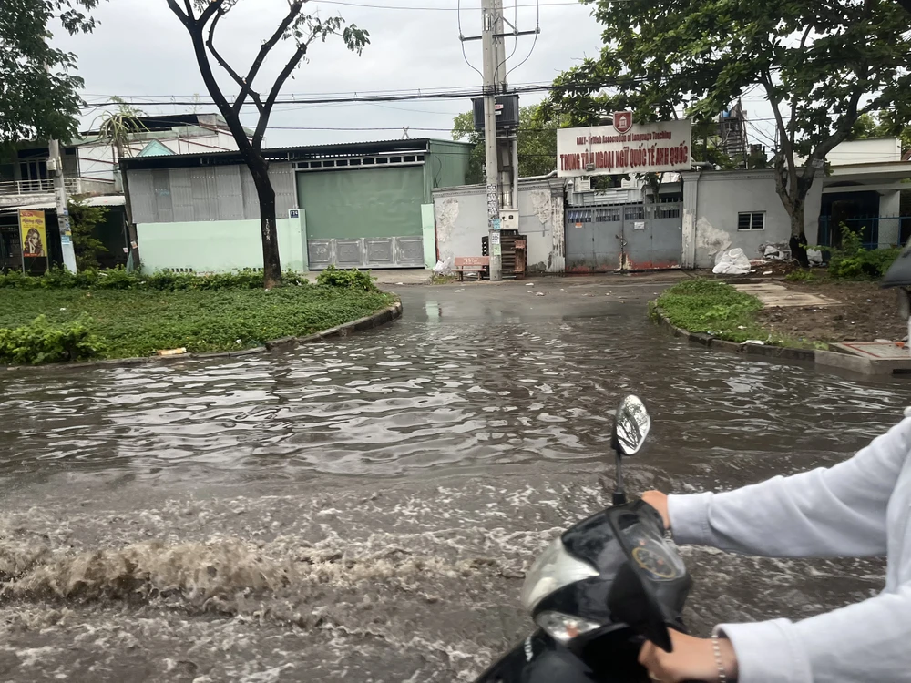 Nước ngập sâu, bắn tung tóe khiến người điều khiển xe máy gặp nhiều khó khăn. Ảnh: ĐÀO TRANG