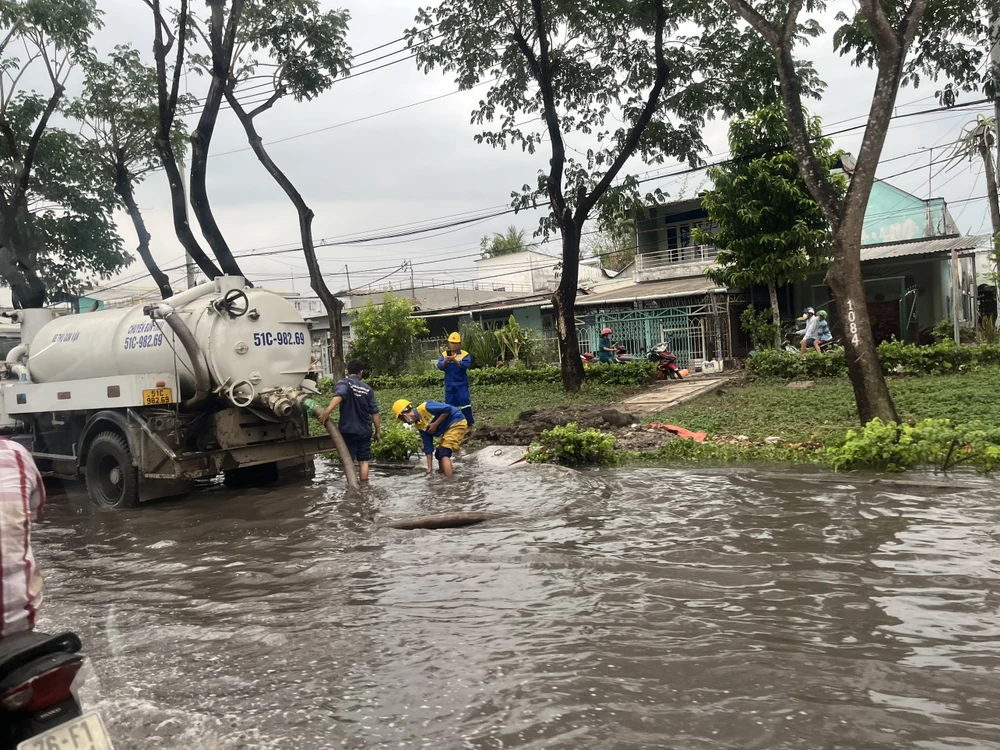 Tới 17 giờ chiều, nước trên đường Trần Văn Giàu vẫn chưa rút. Ảnh: ĐÀO TRANG