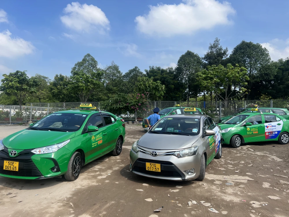 Thanh tra giao thông kiểm tra đột xuất các điều kiện hoạt động của các taxi ở bãi đệm sân bay Tân Sơn Nhất. Ảnh: ĐÀO TRANG