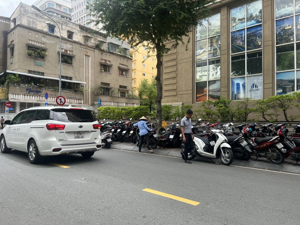 Bãi đậu xe tự phát trên lề đường. Ảnh: ĐÀO TRANG