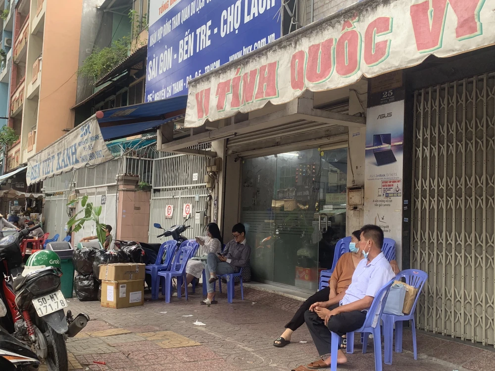 Hành khách đi xe ngồi chờ trên đường Nguyễn Chí Thanh, quận 5.