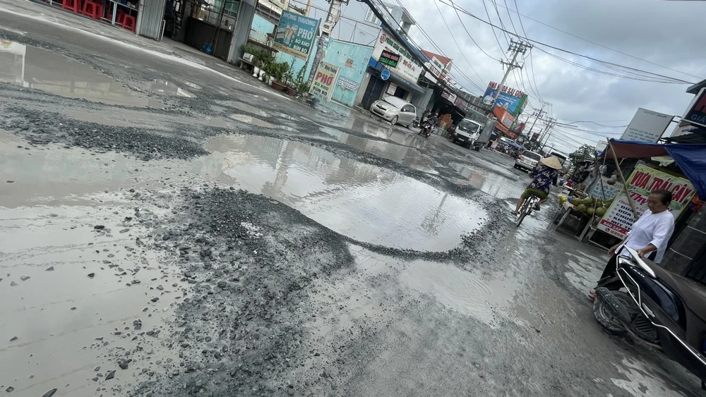 Người dân di chuyển qua khu vực phải cẩn thận luồn lách để tránh ổ voi, ổ gà.