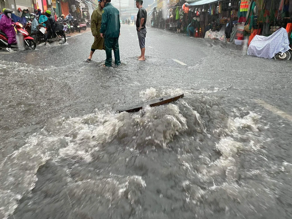 Nắp cống bung lên hạ xuống ở khu vực chợ Thủ Đức. Ảnh: ĐÀO TRANG