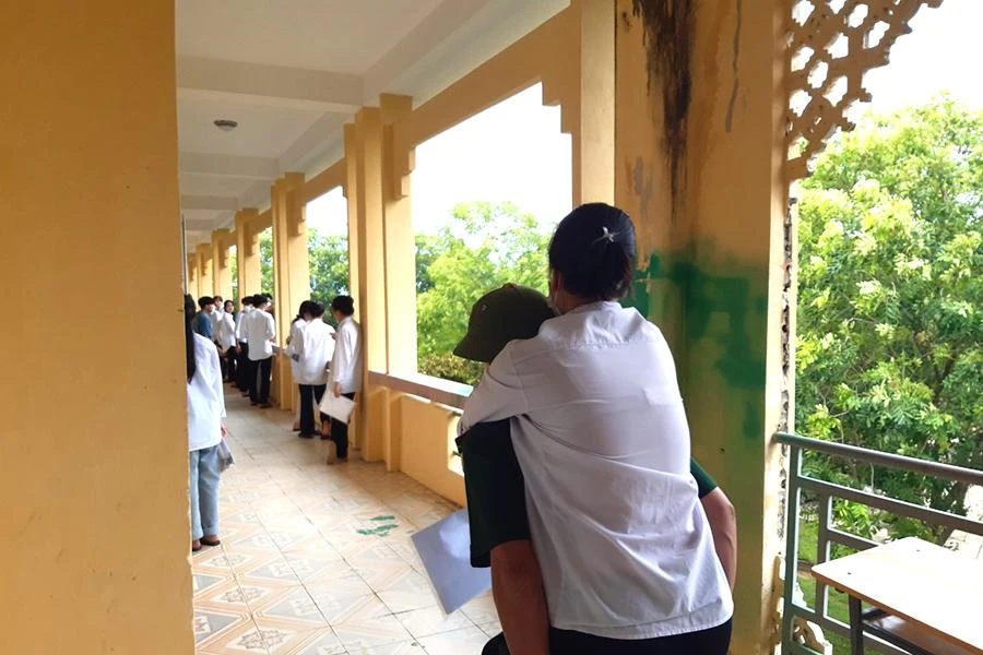 Nguyễn Thị Thùy được cán bộ chiến sĩ biên phòng Đồn biên phòng Đa Lộc (Hậu Lộc) cõng đến tận phòng thi. Ảnh: H.D