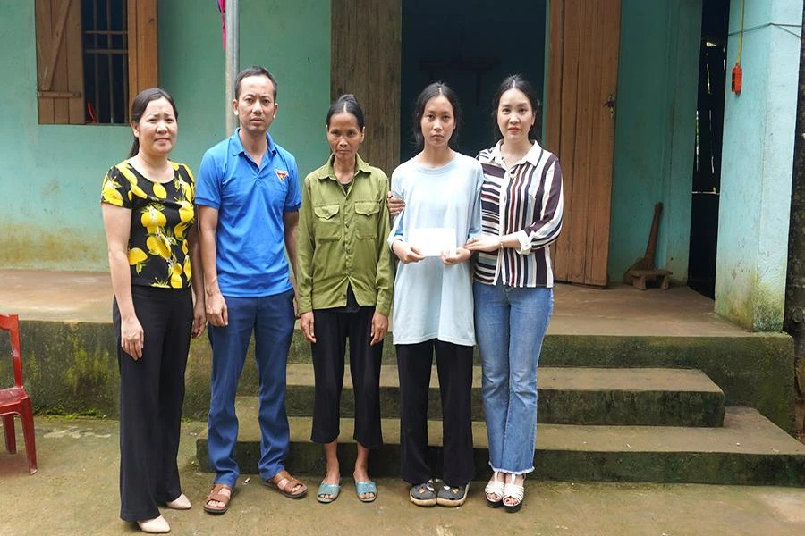 Phó Hiệu trưởng Trường THPT Dân tộc nội trú tỉnh Thanh Hóa bà Bùi Thị Kiều Oanh cùng đoàn thể chính quyền địa phương trao món quà nhỏ động viên Thúy tiếp tục đến với giảng đường đại học. Ảnh: Đ.TRUNG