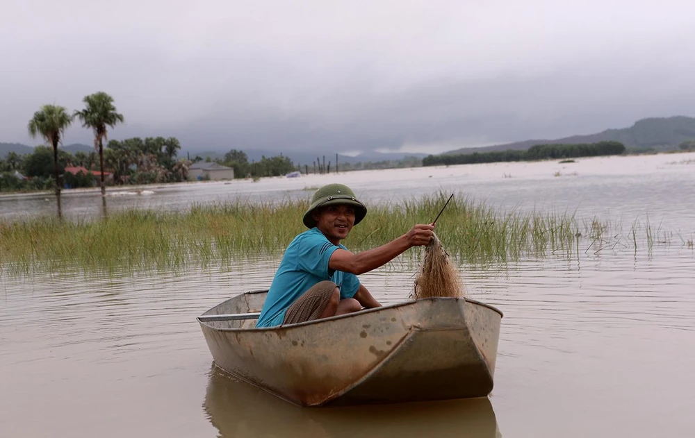 Nước lũ về một người dân tranh thủ đi thả lưới để cải thiện bữa ăn. Ảnh: ĐẶNG TRUNG