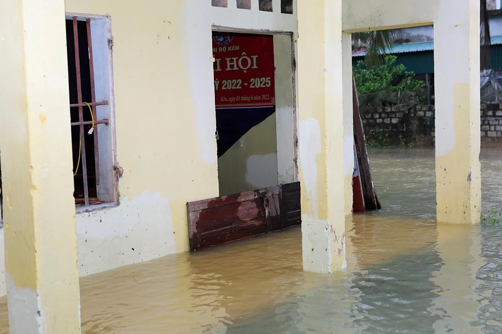 Cánh cửa hội trường của thôn được tháo xuống để ngăn nước vào bên trong nhằm làm giảm bớt thiệt hai do lũ. Ảnh: ĐẶNG TRUNG
