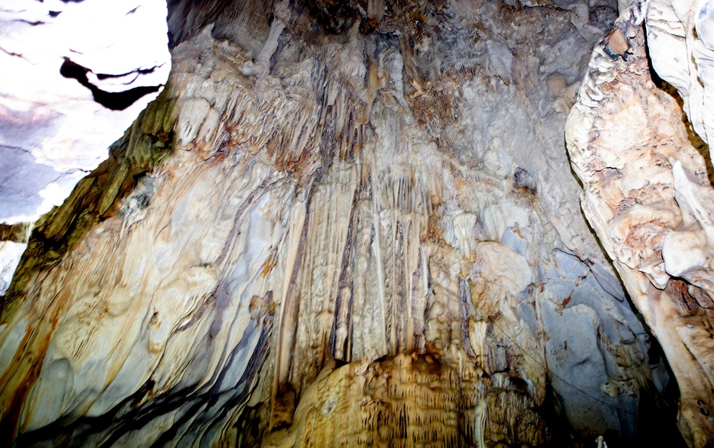 Phiến đá có hình thù như cột chống trời giữa nền mây trắng bạc hai bên. Ảnh: ĐẶNG TRUNG