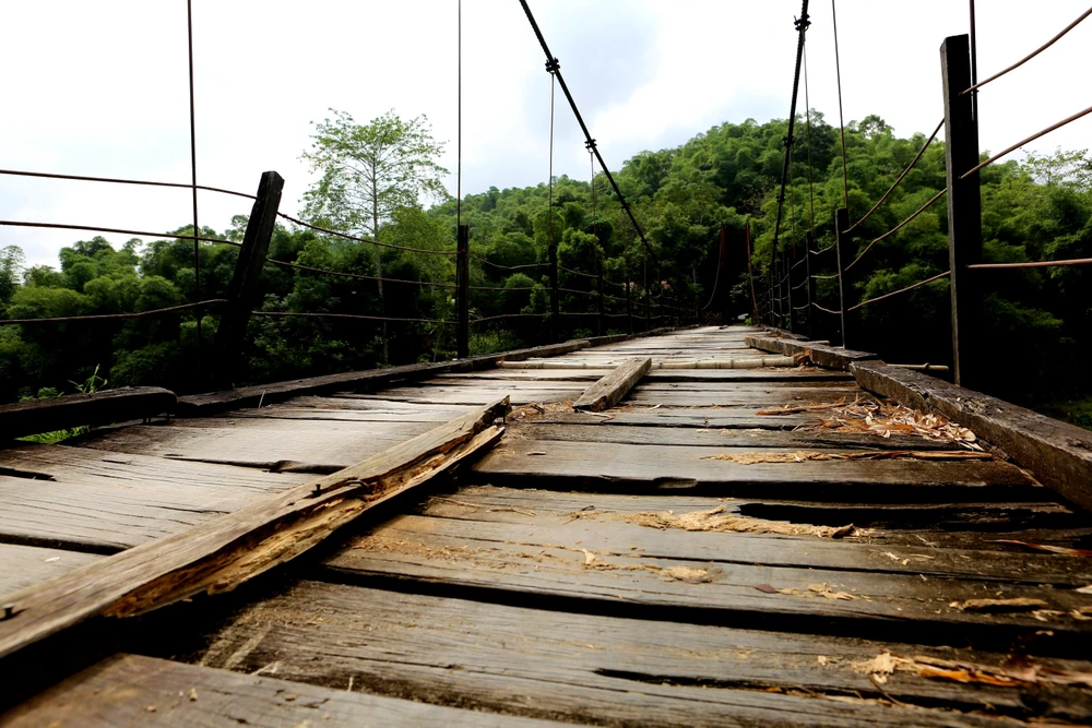 Nhiều ván gỗ giữa mặt cầu đã bị mục nát, lõm xuống. Ảnh: ĐẶNG TRUNG