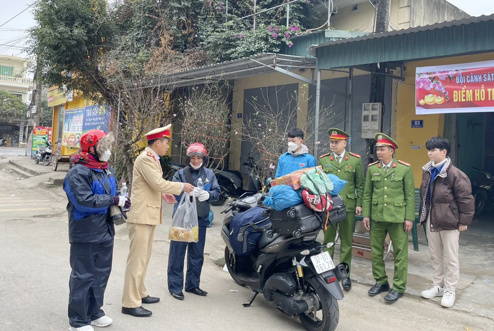 CSGT huyện Quảng Xương hỗ trợ nhu yếu phẩm cho người dân trên đường về quê ăn Tết qua địa bàn. Ảnh: Đ.T