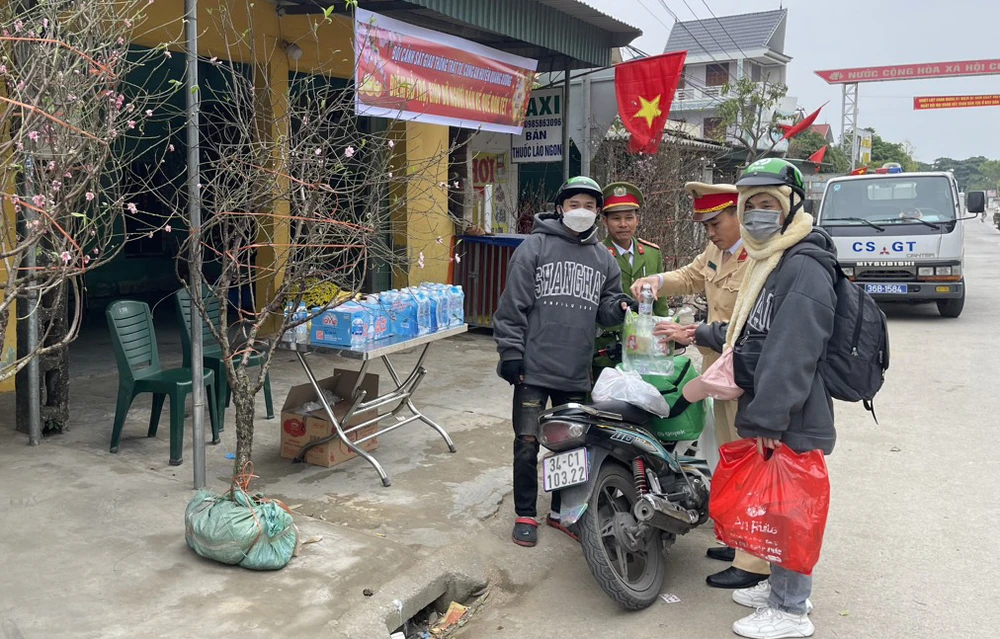 Nhiều người dân cảm thấy ấm lòng khi được các chiến sĩ tặng áo ấm, bánh mì và nước uống trên đường về quê. Ảnh: Đ.T